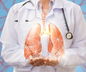 Doctor shows human lungs on blue background.